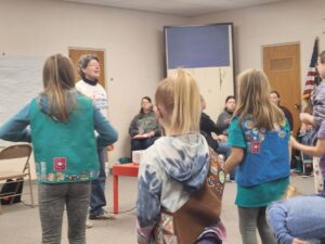 League members help girl scouts earn their democracy badges.